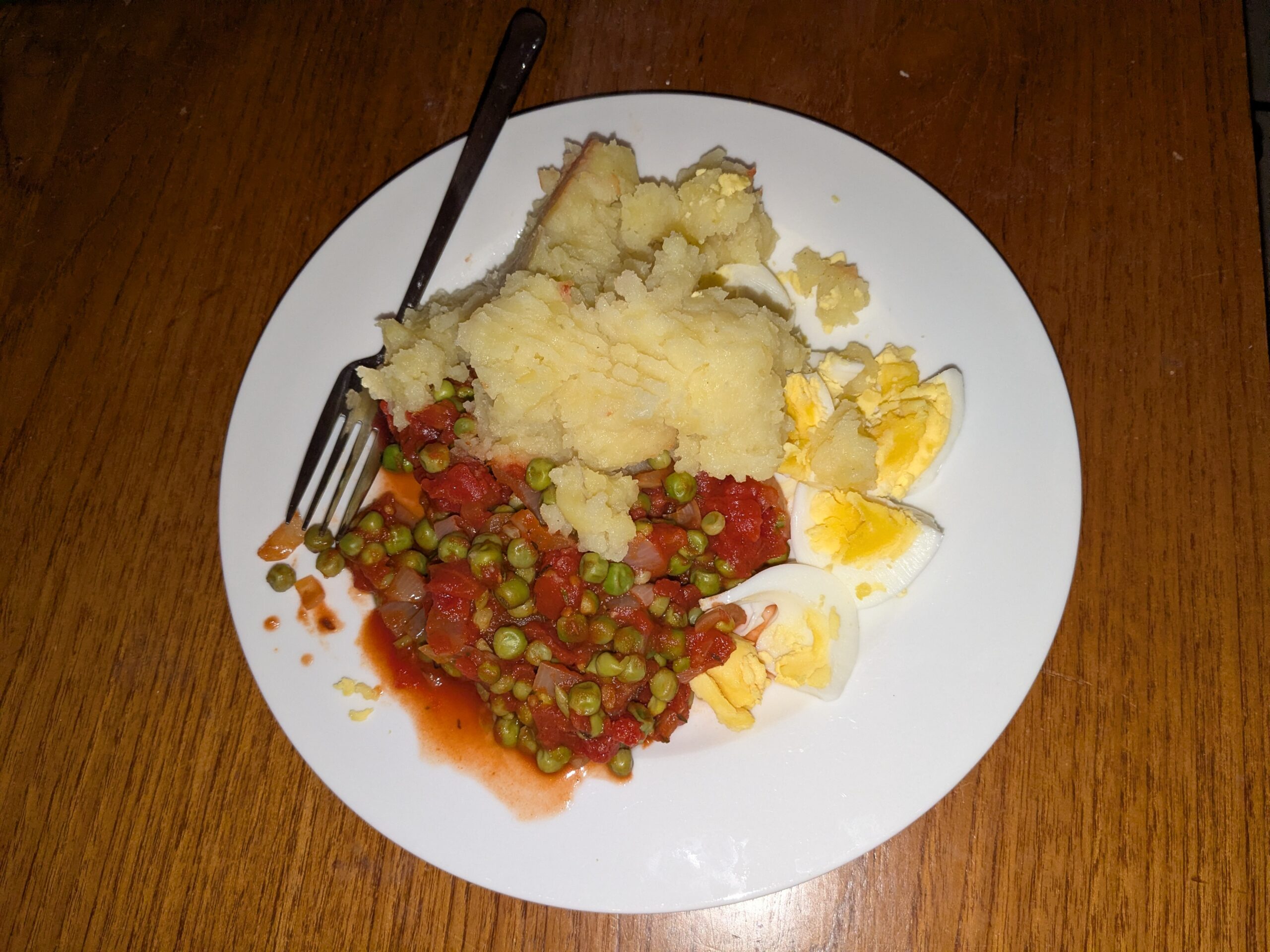 Gestoofde doperwten met tomaat, aardappelpuree en ei